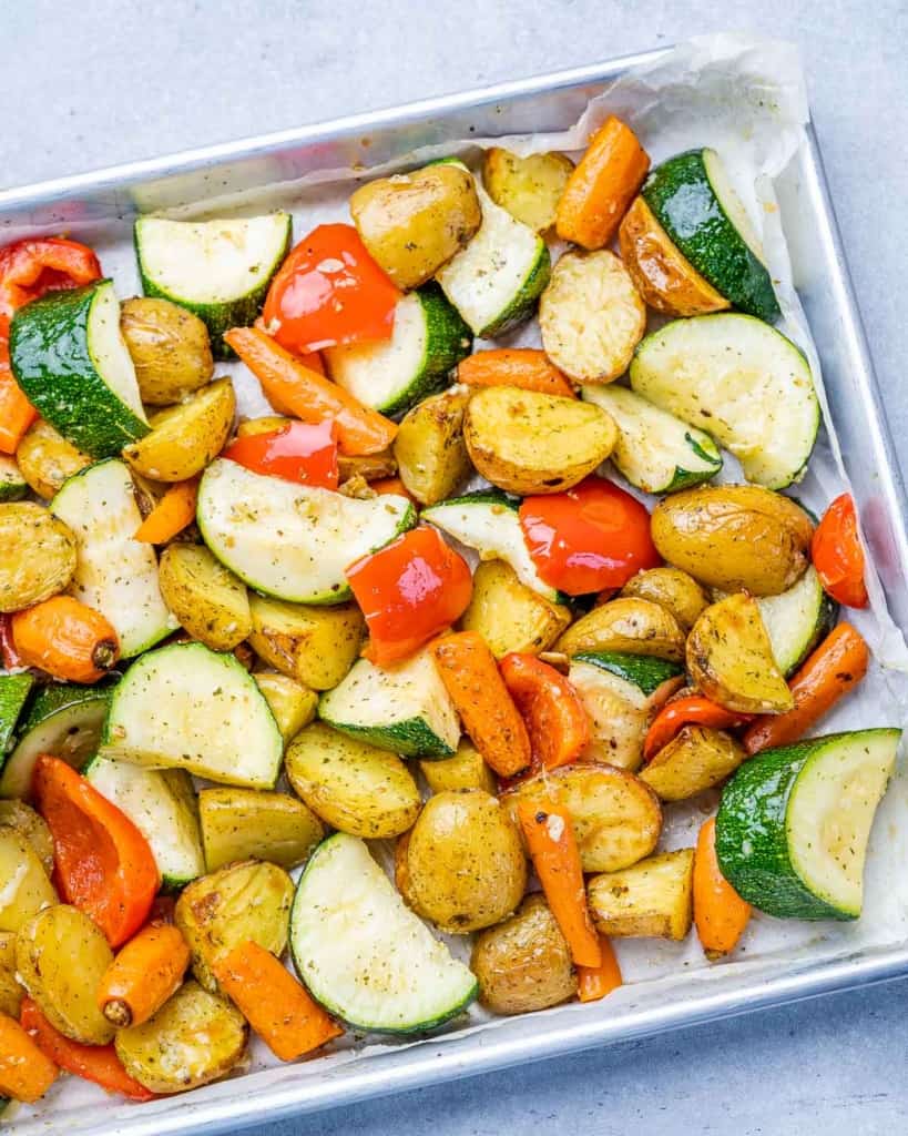Potatoes roasted with carrots and zucchini on a pan.