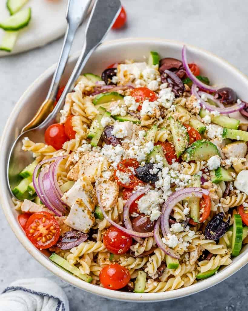Salad made with chicken, pasta and veggies in a large serving bowl.