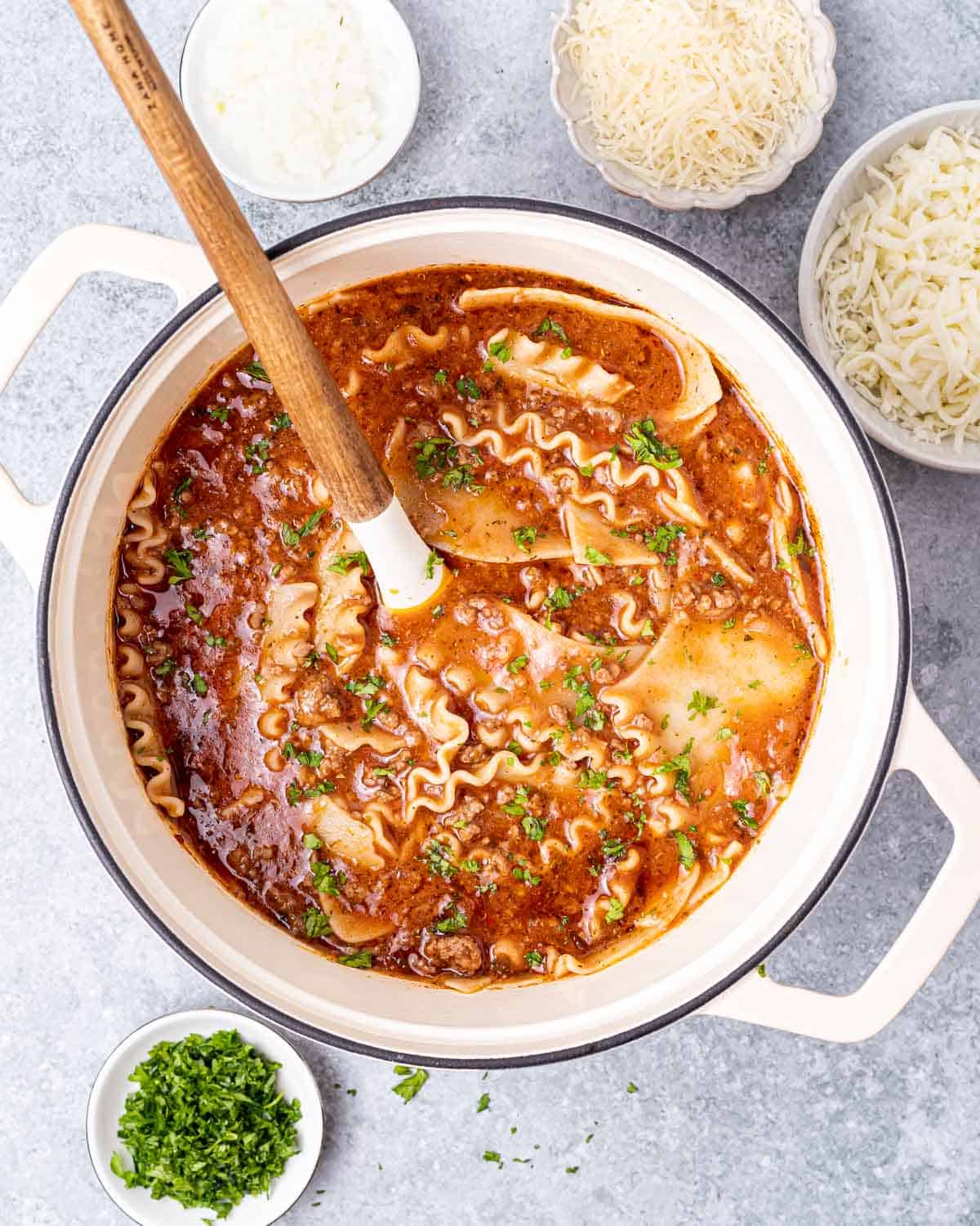 Stirring lasagna soup in a dutch oven.