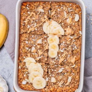 top view baked oatmeal in a white dish topped with sliced bananas