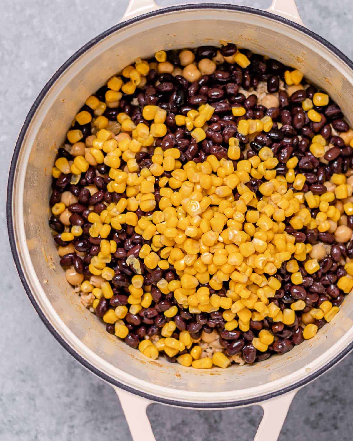 Black beans and corn mixed with ground turkey in a large pot.