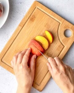 slicing peaches on a cutting board.