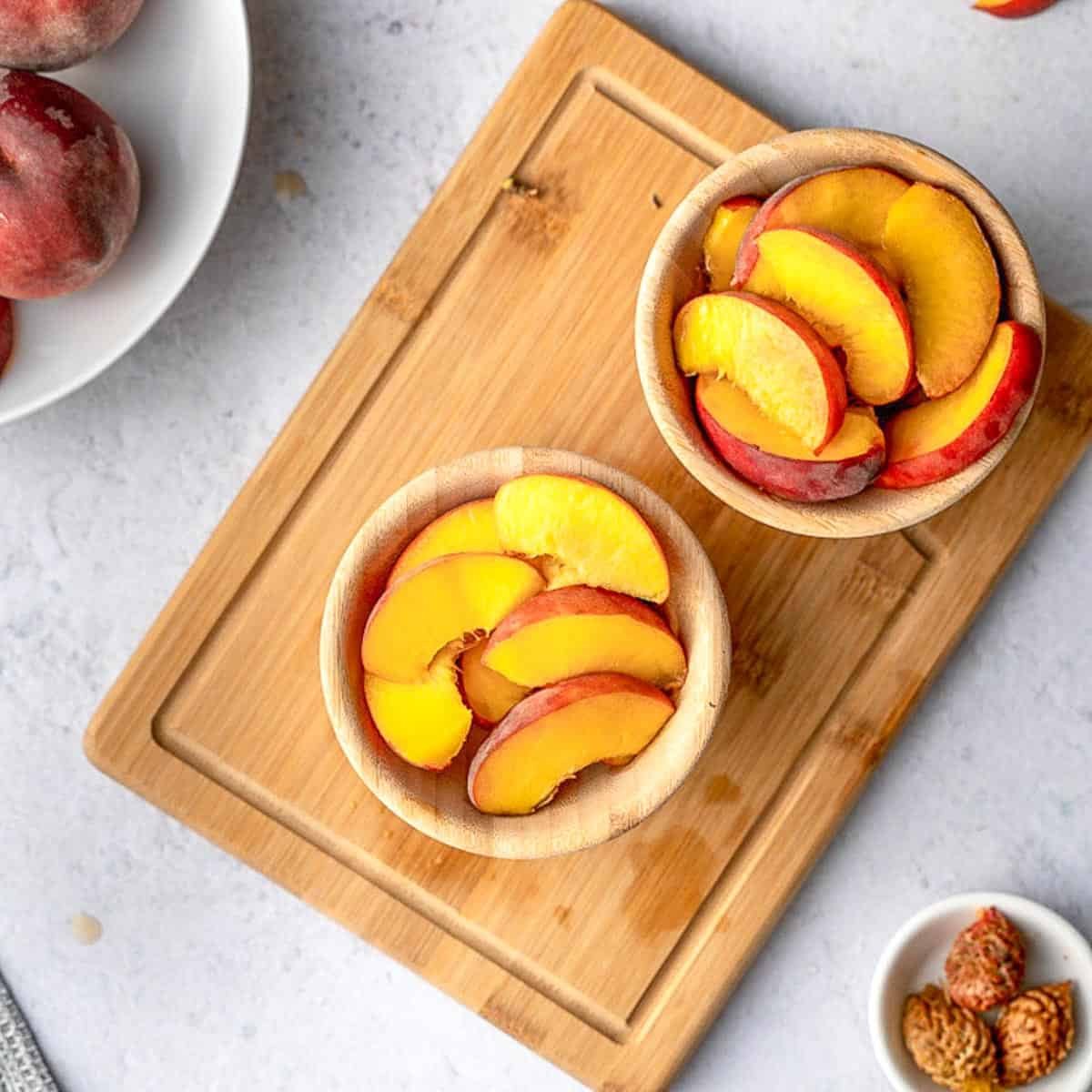 Sliced peaches in 2 round bowls.