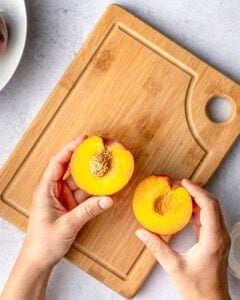 holding 2 half peach slices.