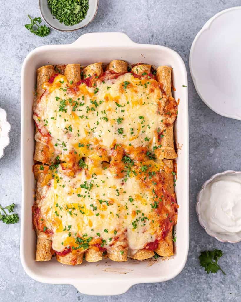 Baked enchiladas topped with cheese and cilantro.