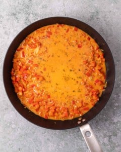 Simmering a creamy red sauce in a skillet.