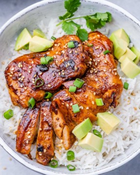 top view sliced korean chicken thighs over a plate of rice in a bowl