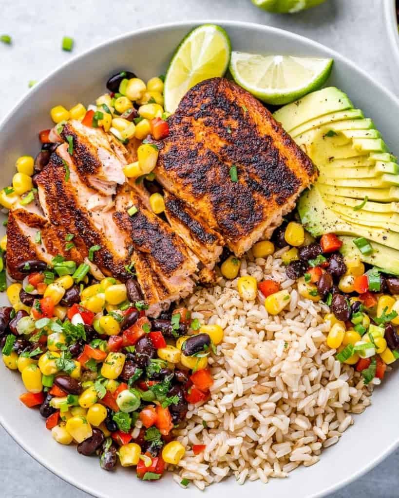 Bowls with brown rice, salmon and black bean salsa.