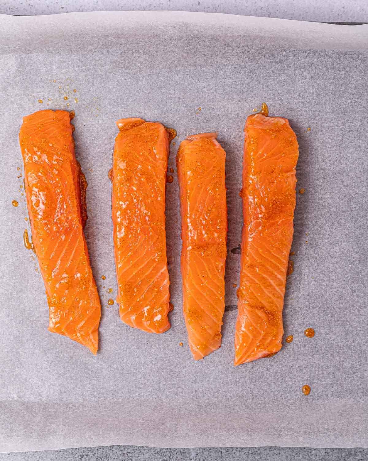 Coating salmon filets in spices.