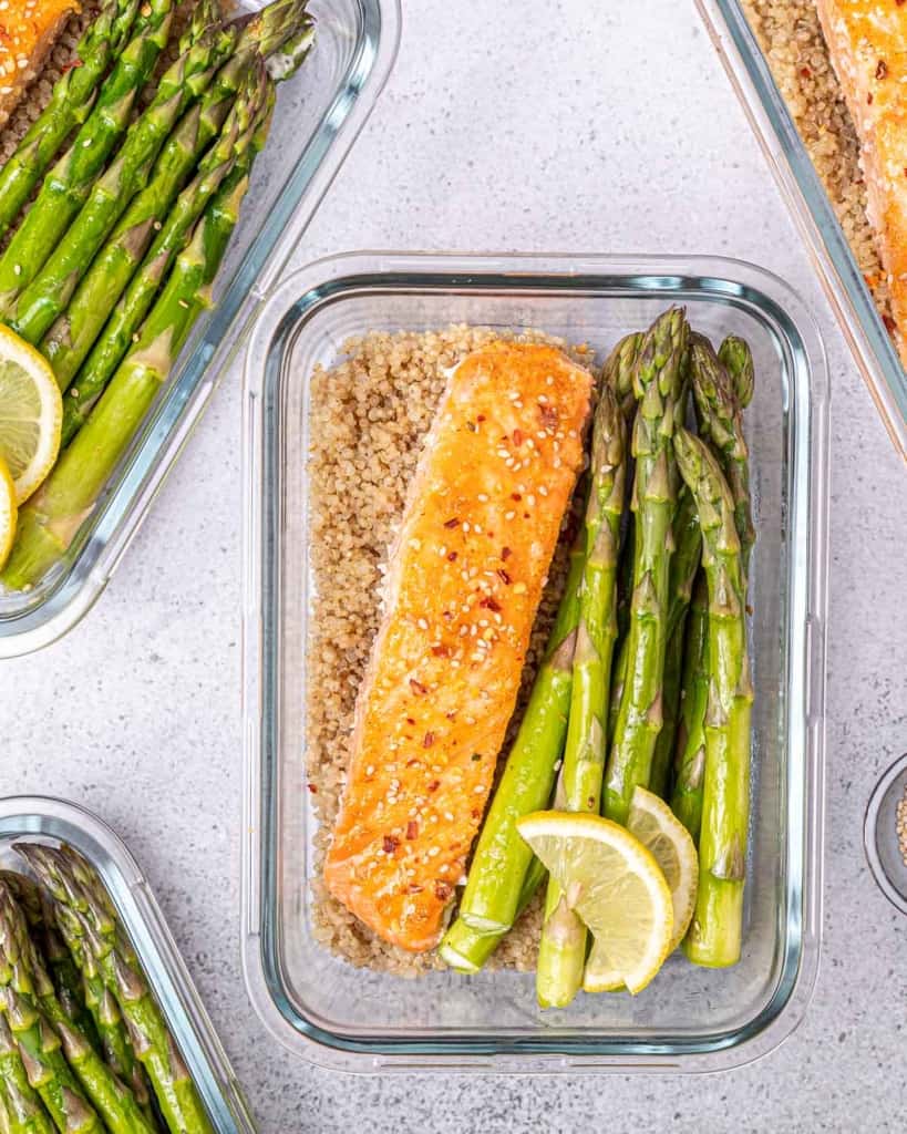 Baked honey salmon and asparagus served in a meal prep bowl.
