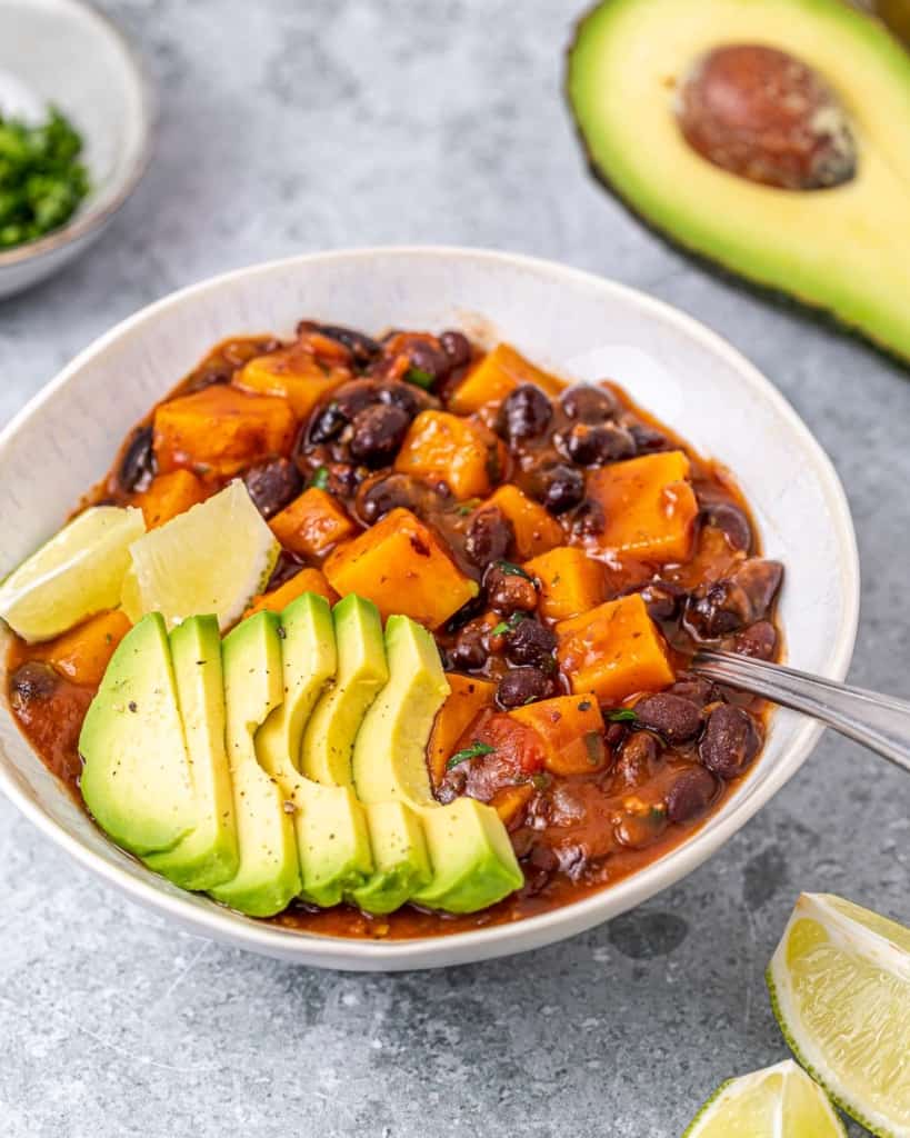 Black bean and sweet potato chili topped with sliced avocado.
