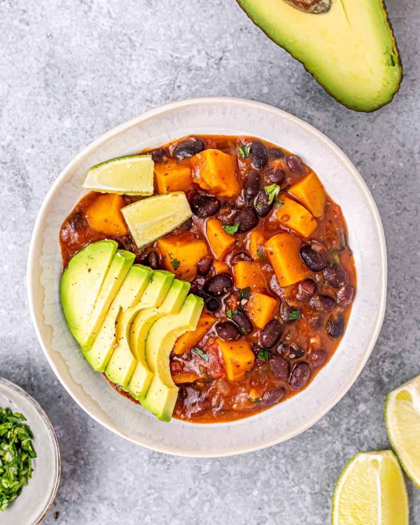 Sweet potato stew with black beans in a white bowl.