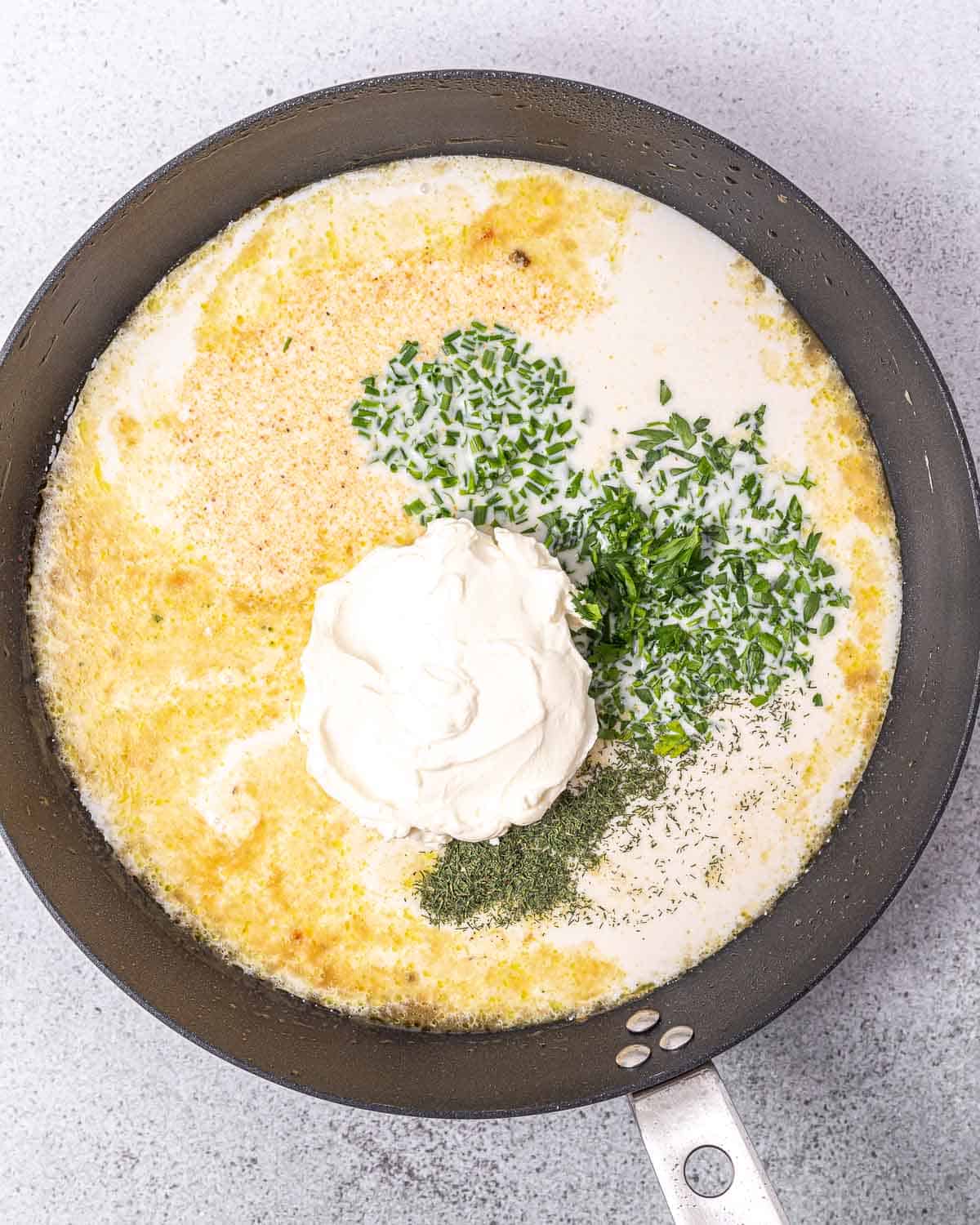 Making a creamy ranch sauce in a pan.