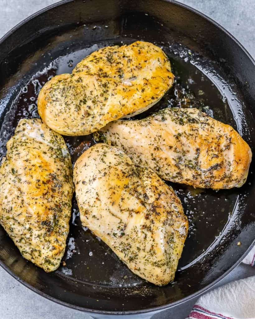 Cooking chicken breasts in a large skillet.