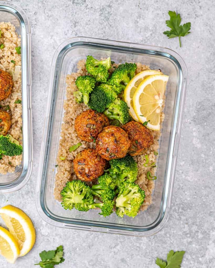 top view meal prep glass bowl with chicken meatballs broccoli and quinoa