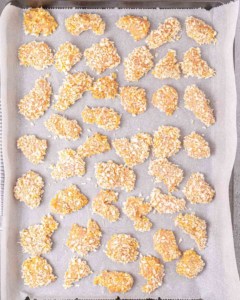 Chicken pieces on a parchment lined baking sheet.