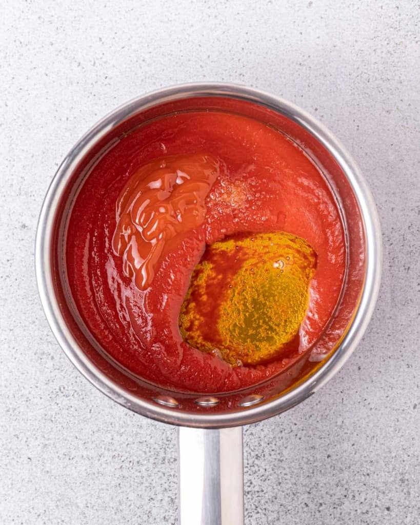 Making a honey sriracha sauce in a sauce pan.
