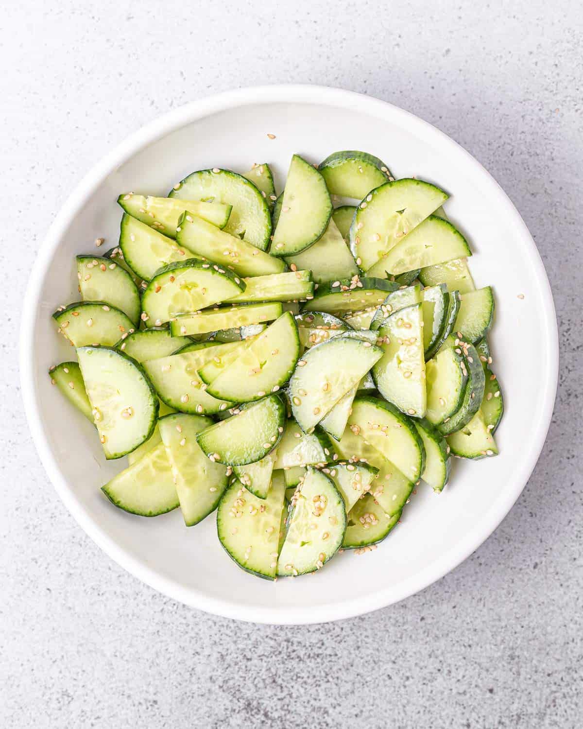Sliced cucumber in a white bowl.
