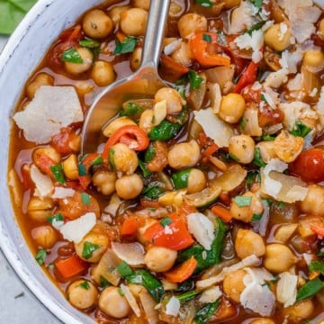 chickpea stew in a white bowl with a spoon in it