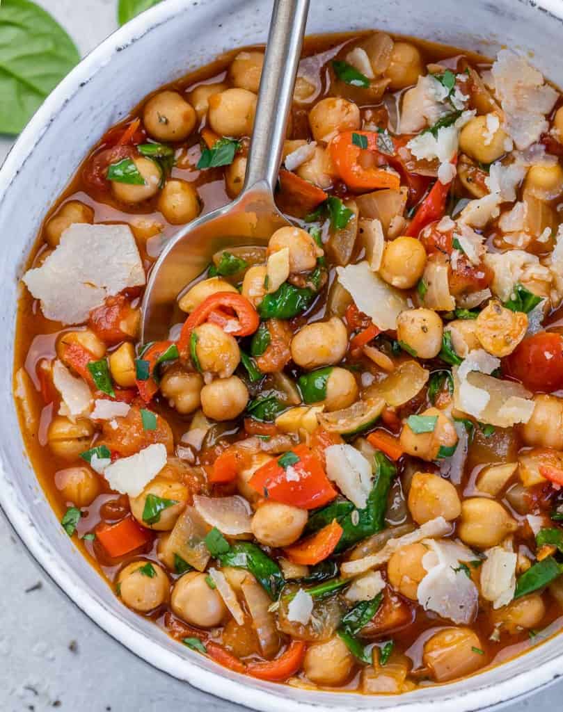 chickpea stew in a white bowl with a spoon in it