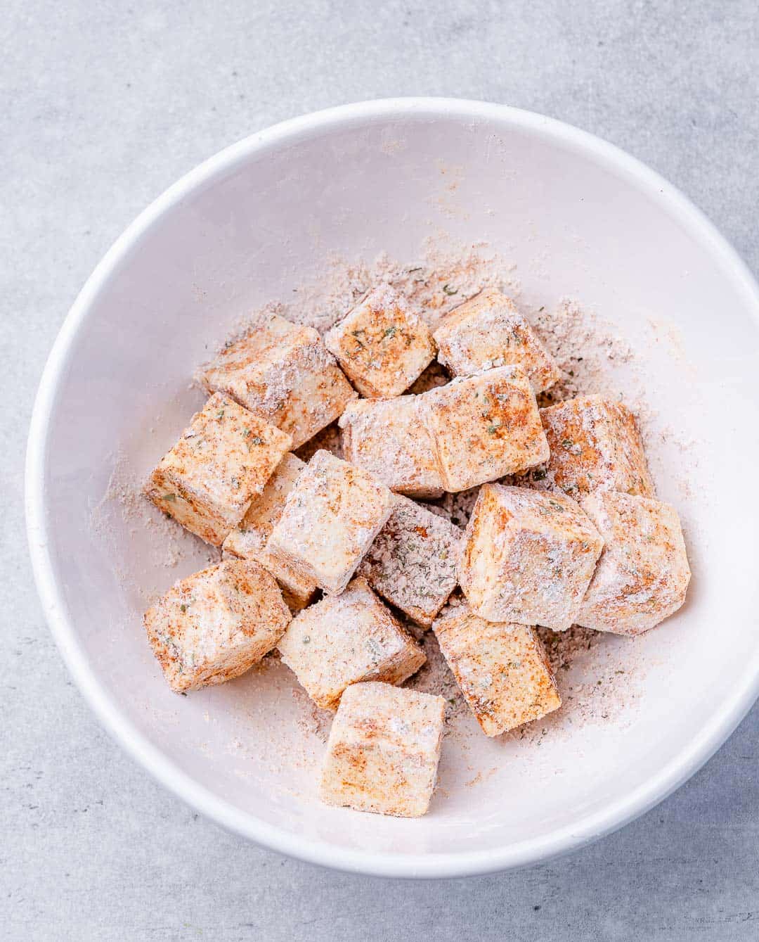 Tossing tofu with salt and cornstarch.