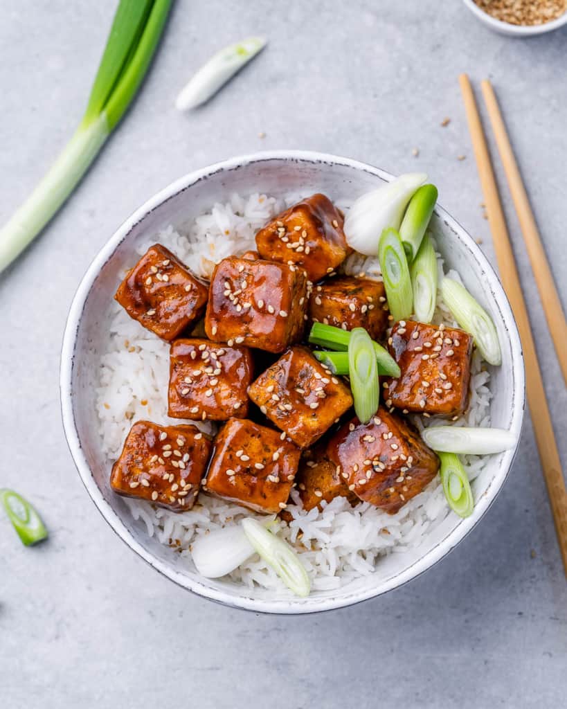 Honey garlic air fryer tofu with rice and topped with green onion.