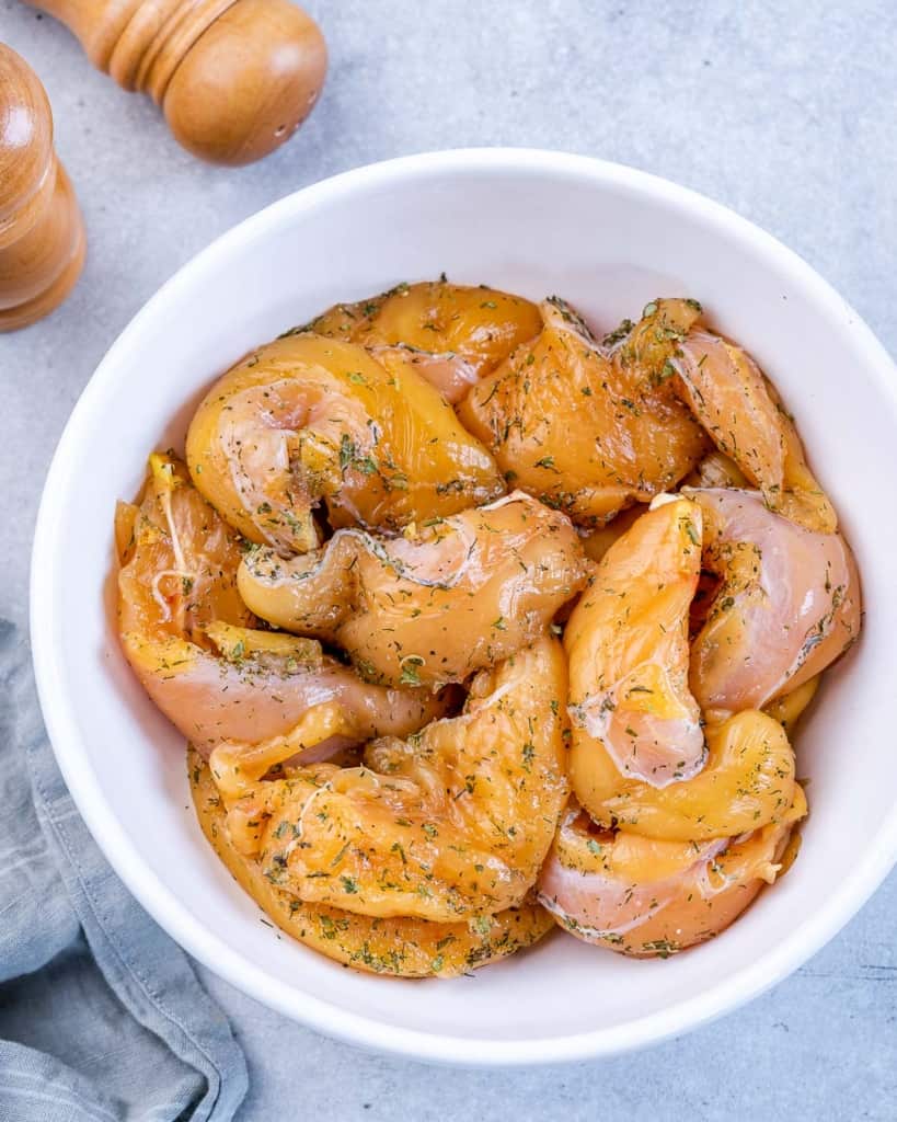 Seasoned chicken tenderloins in a bowl.
