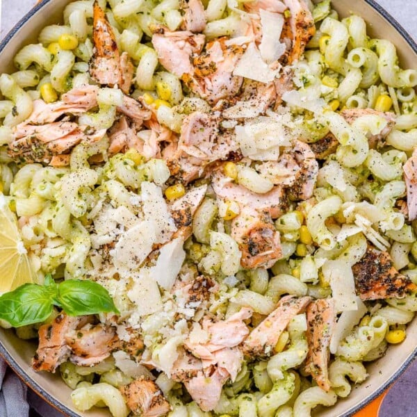 pasta in a bowl topped with salmon flaked into small bite sizes.
