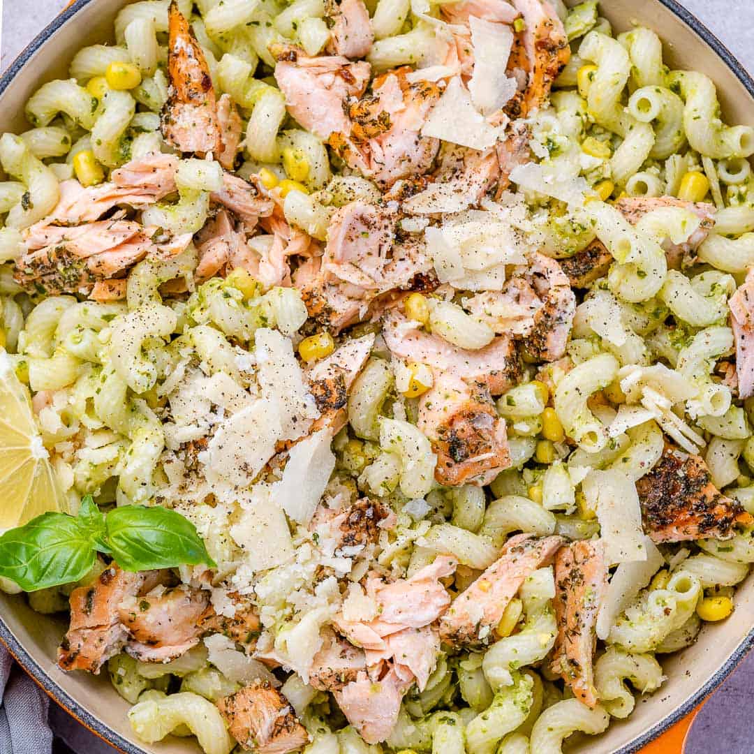 top view pasta in a bowl topped with salmon flaked into smalla bite sizes