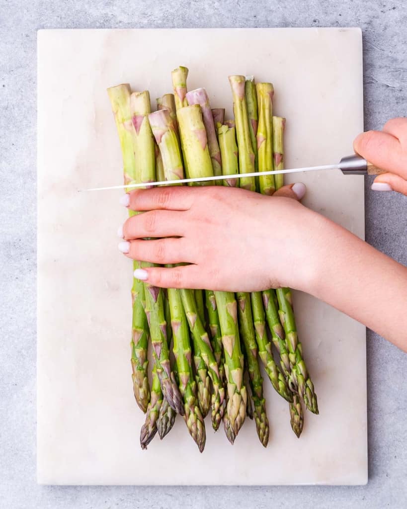 Trimming the ends off of the asparagus.