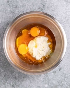 Combining eggs, honey and cream cheese in a large bowl.
