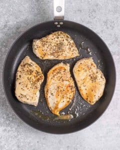 seared chicken breast in a black skillet.