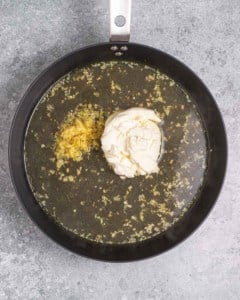 broth, lemon juice, and cream cheese added to the pan.