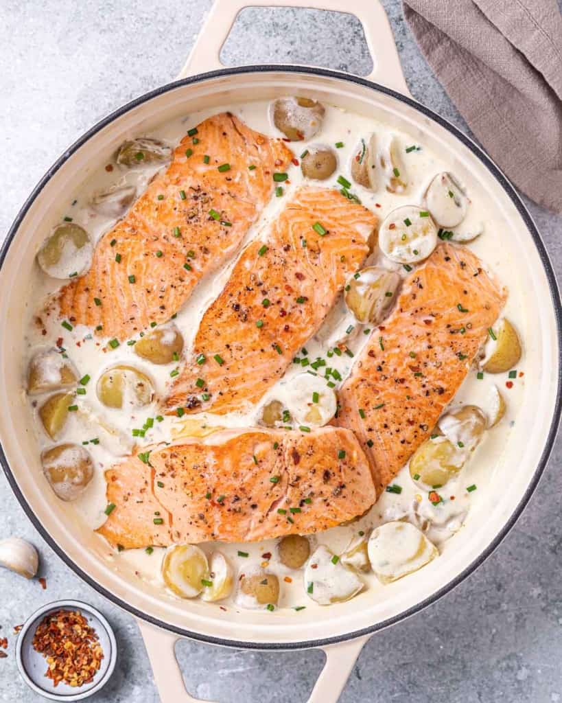 top view salmon in white sauce with baby potatoes