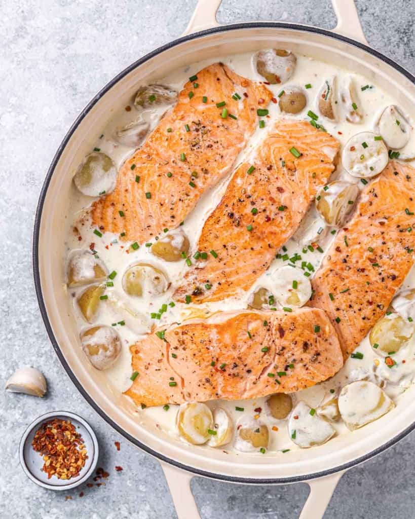 top view salmon in a creamy garlic sauce with baby potatoes