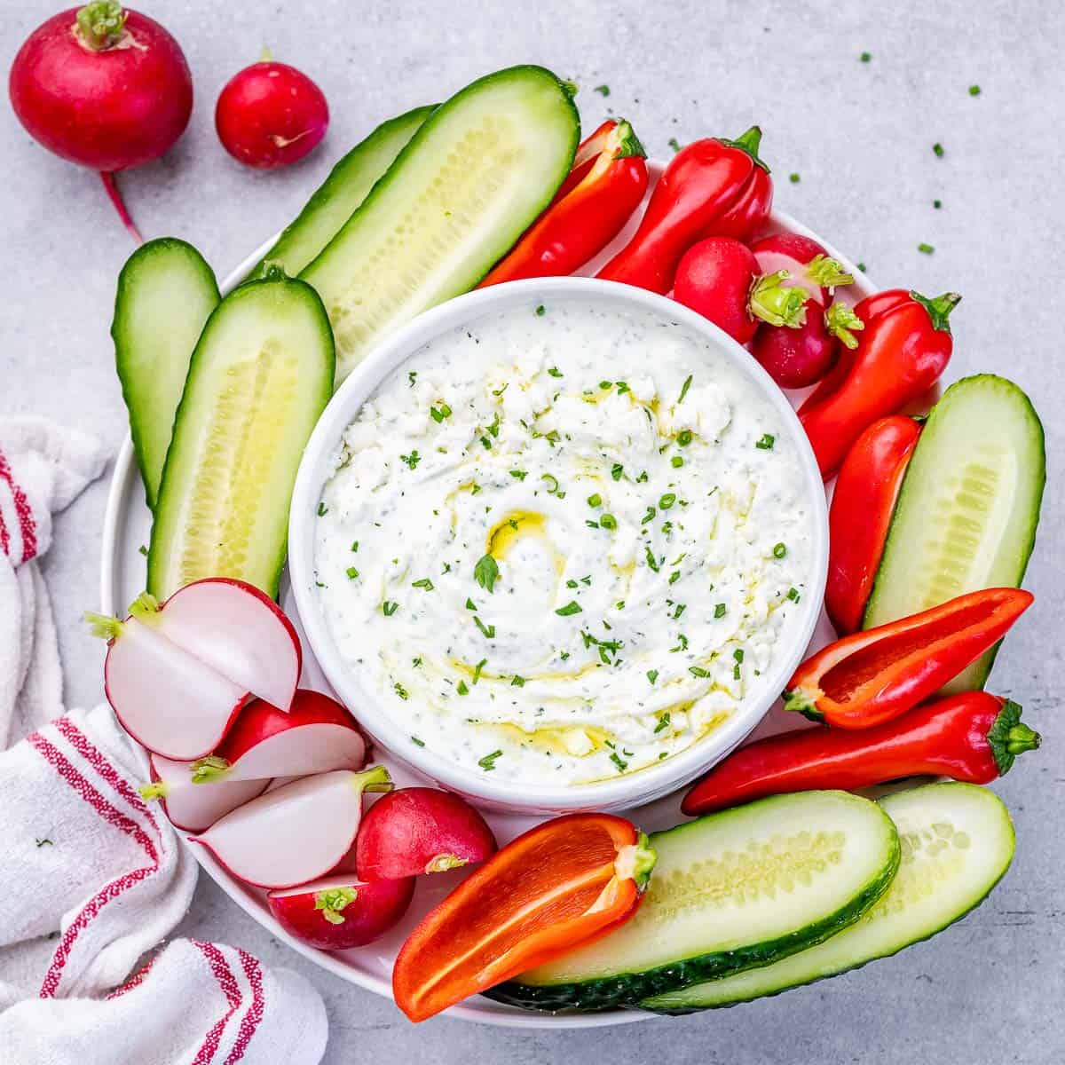 top view feta dip in a bowl with veggies on the side