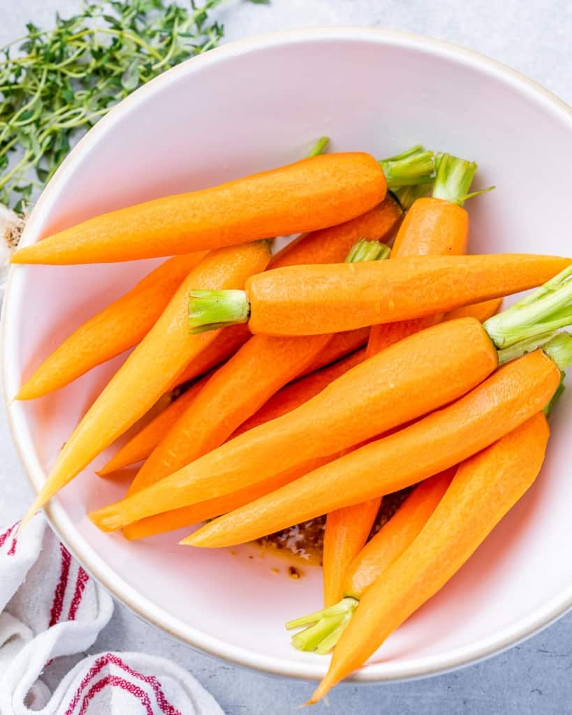 Peeled carrots in a white bowl.