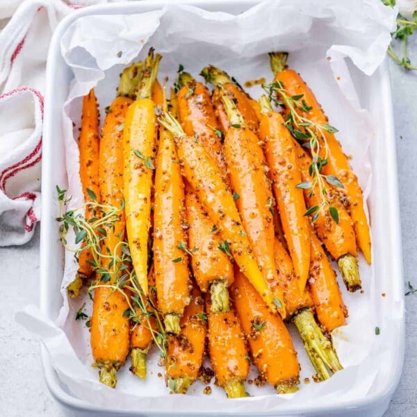 roasted carrots in a honey mustard sauce in a white dish.