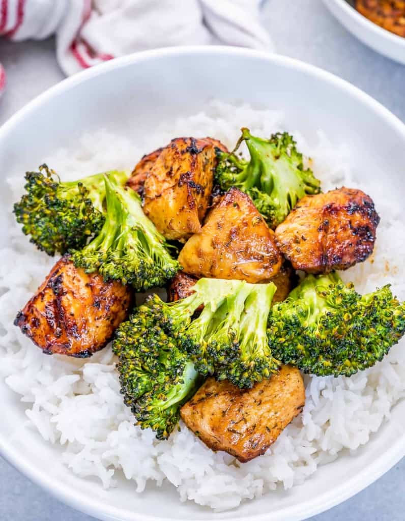 top view round plate of rice topped with air fried chicken bites and broccoli