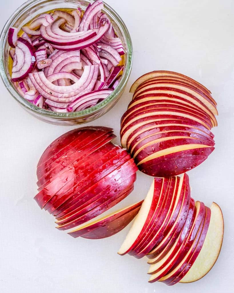 sliced apples and onions on a cutting board