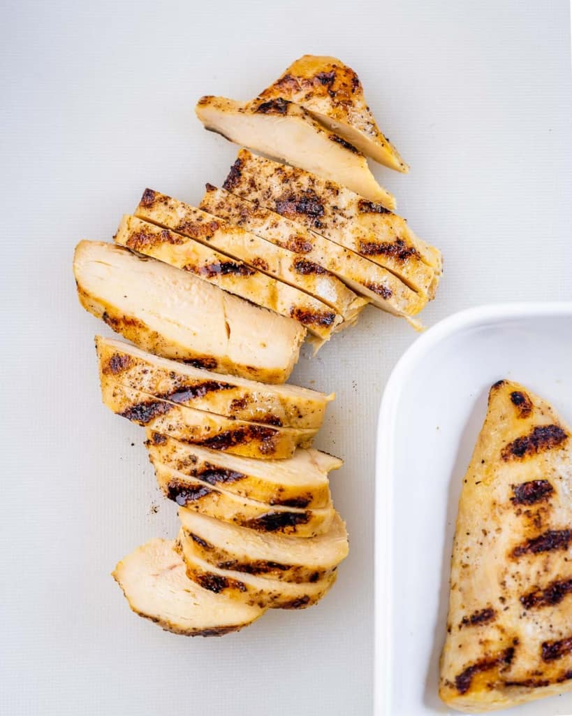 sliced grilled chicken breast on a cutting board
