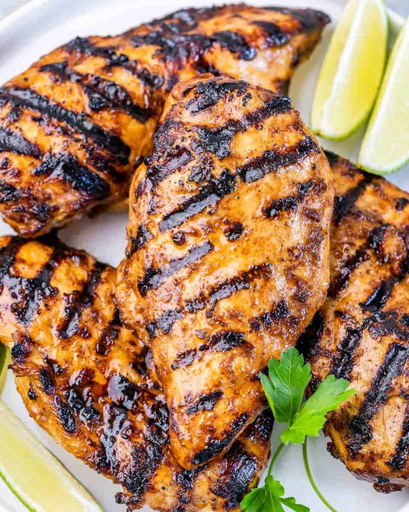 Grilled chicken with grill marks on a white plate.