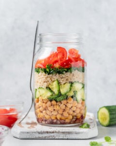 A jar salad with the lid removed near a fork.