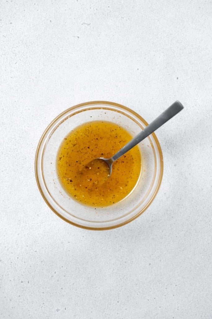 Mixing a vinaigrette in a small bowl.
