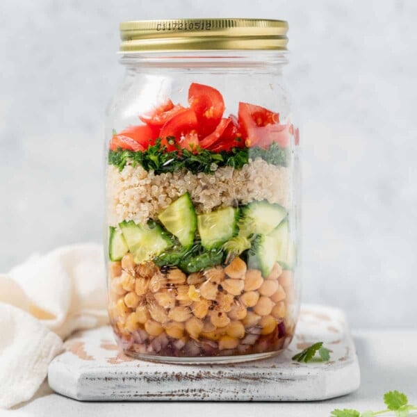 side shot of quinoa and chickpea salad in a mason jar