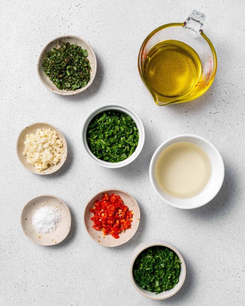 ingredients needed to make chimichurri sauce  laid out on a flat surface 