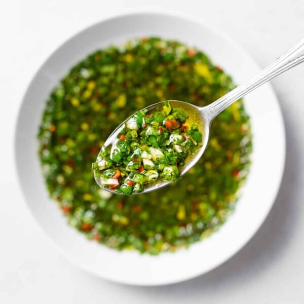 spoonful of chimichurri over a bowl of chimichurri sause