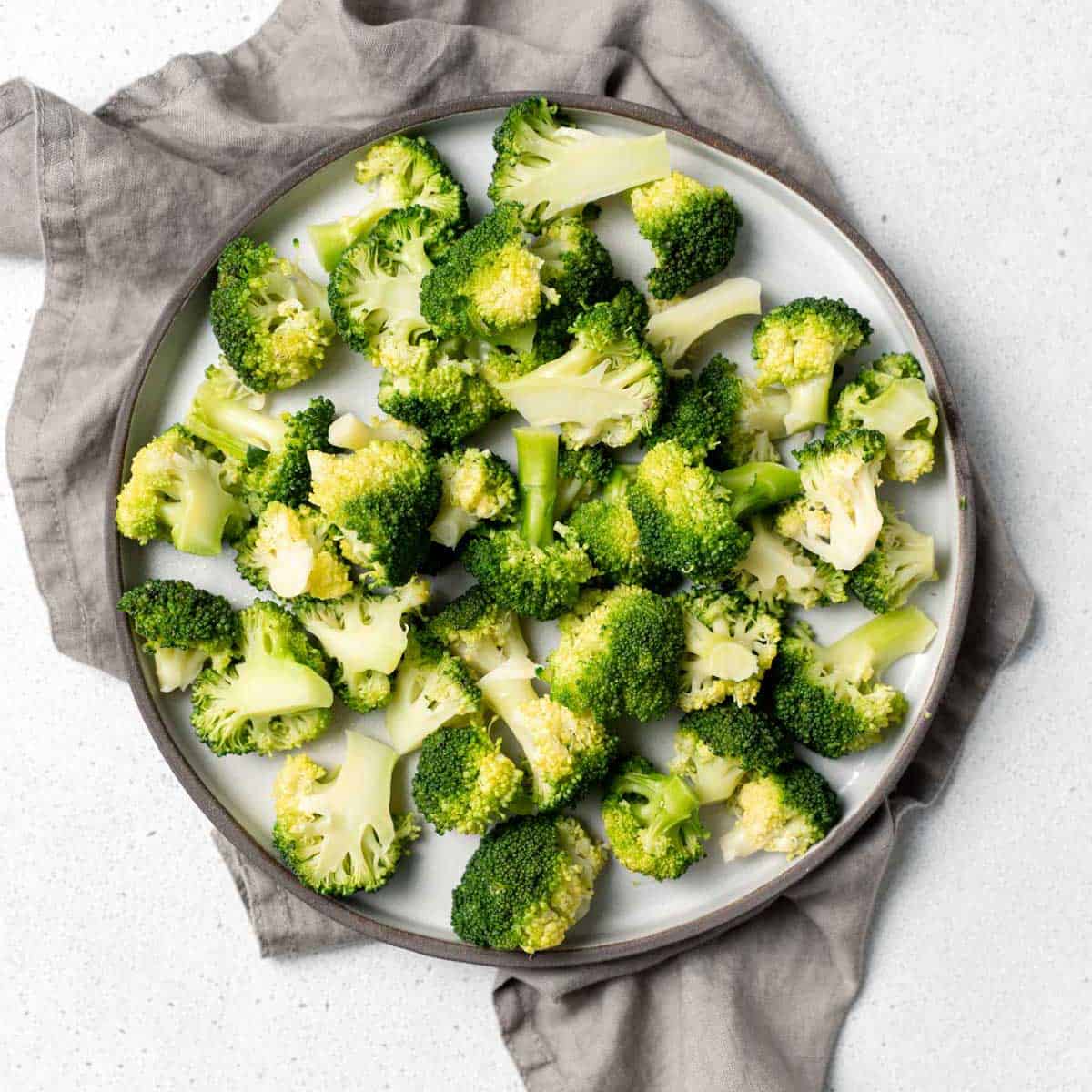 top view cooked broccoli on a round white plate