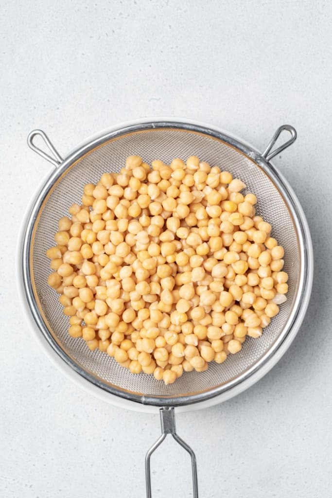 Draining chickpeas in a strainer.