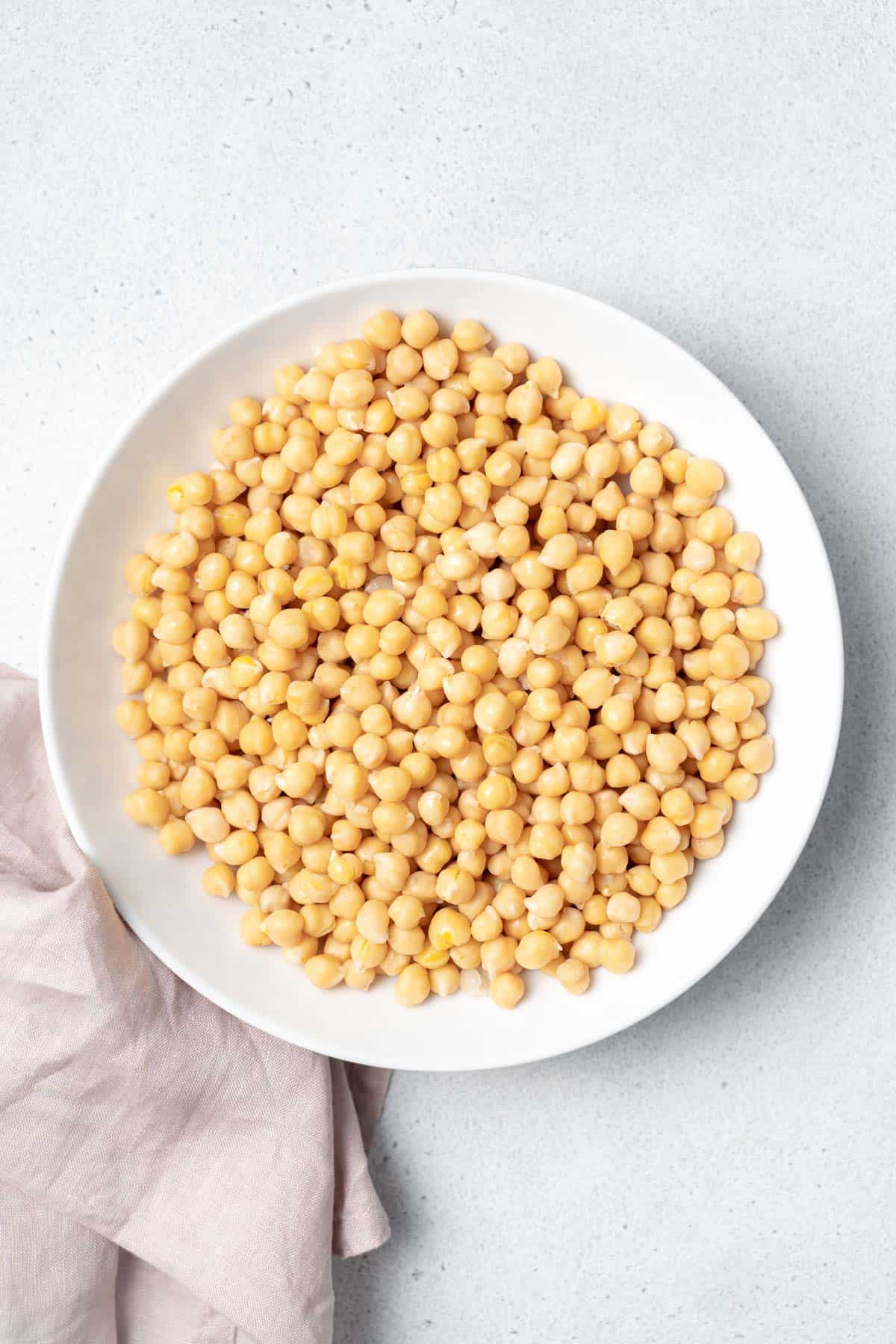 Cooked chickpeas in a white bowl.